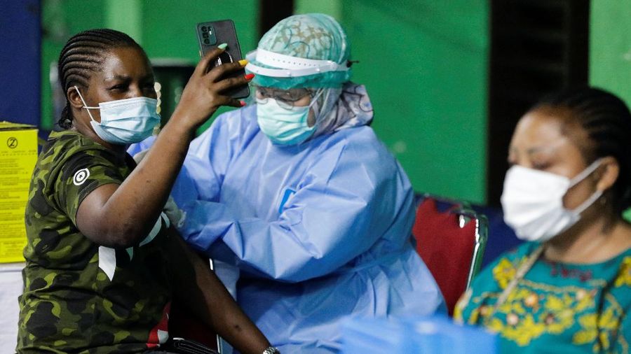 A woman undergoes a health screening before receiving a dose of a vaccine against the coronavirus disease (COVID-19) during a mass vaccination program for asylum seekers and refugees at a sports hall in Jakarta, Indonesia, October 7, 2021. REUTERS/Ajeng Dinar Ulfiana