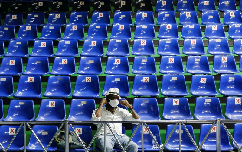 A woman undergoes a health screening before receiving a dose of a vaccine against the coronavirus disease (COVID-19) during a mass vaccination program for asylum seekers and refugees at a sports hall in Jakarta, Indonesia, October 7, 2021. REUTERS/Ajeng Dinar Ulfiana