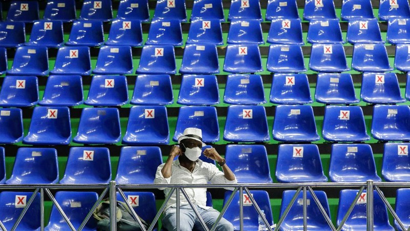 A woman undergoes a health screening before receiving a dose of a vaccine against the coronavirus disease (COVID-19) during a mass vaccination program for asylum seekers and refugees at a sports hall in Jakarta, Indonesia, October 7, 2021. REUTERS/Ajeng Dinar Ulfiana