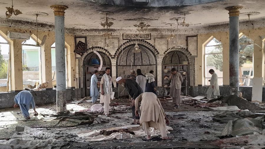 People carry the body of a victim following a bombing in Kunduz province, northern Afghanistan, Friday, Oct. 8, 2021. A powerful explosion in a mosque frequented by a Muslim religious minority in northern Afghanistan on Friday has left several casualties, witnesses and the Taliban's spokesman said. (AP Photo/Abdullah Sahil)