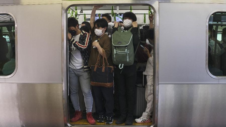 Passengers wait in a long line to get into JR Kawaguchi station in Kawaguchi, near Tokyo Friday, Oct. 8, 2021. Entry to the station was restricted due to aftermath of Thursday's strong earthquake. (Kyodo News via AP)