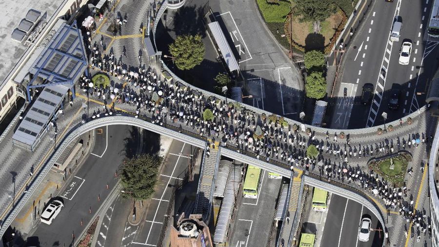 Passengers wait in a long line to get into JR Kawaguchi station in Kawaguchi, near Tokyo Friday, Oct. 8, 2021. Entry to the station was restricted due to aftermath of Thursday's strong earthquake. (Kyodo News via AP)