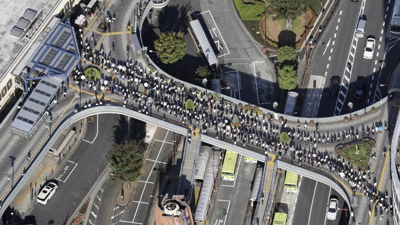 Passengers wait in a long line to get into JR Kawaguchi station in Kawaguchi, near Tokyo Friday, Oct. 8, 2021. Entry to the station was restricted due to aftermath of Thursday's strong earthquake. (Kyodo News via AP)
