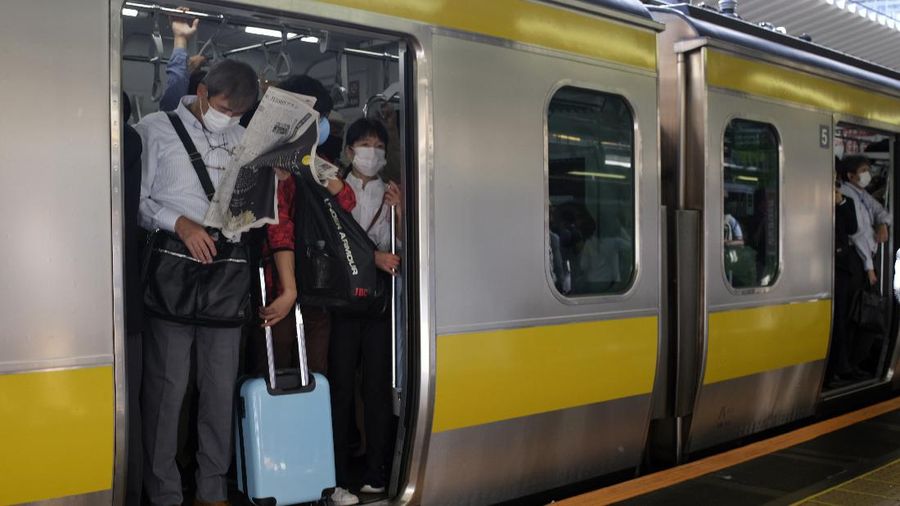 Passengers wait in a long line to get into JR Kawaguchi station in Kawaguchi, near Tokyo Friday, Oct. 8, 2021. Entry to the station was restricted due to aftermath of Thursday's strong earthquake. (Kyodo News via AP)