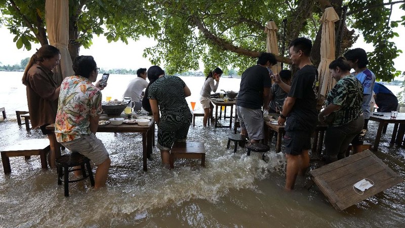 Banjir bikin Restoran di Thailand ramai pengunjung. (AP/Sakchai Lalit)