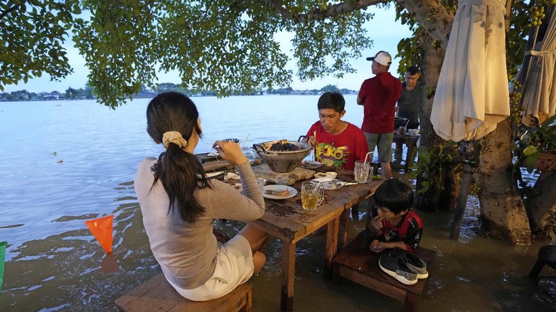 Banjir bikin Restoran di Thailand ramai pengunjung. (AP/Sakchai Lalit)