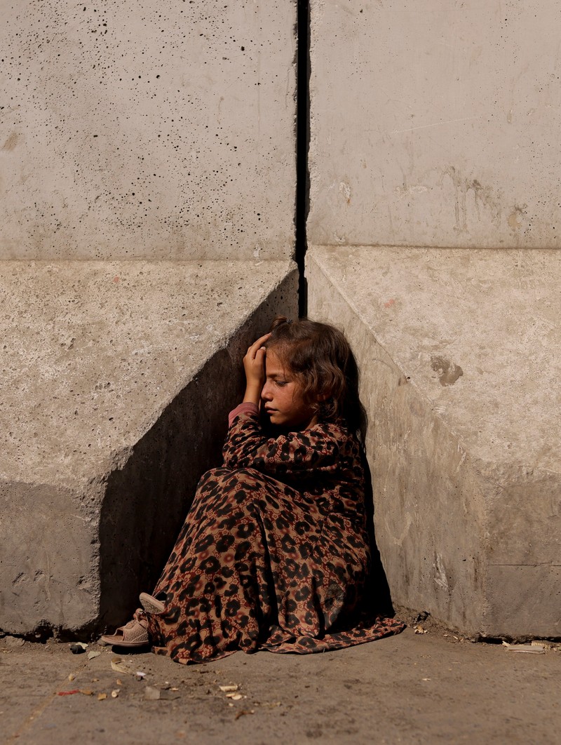 Seorang wanita Afghanistan mengenakan burqa memohon saat merawat putrinya di Kabul, Afghanistan 7 Oktober 2021. (REUTERS/Jorge Silva) An Afghan woman wearing a burqa begs while taking care of her daughter in Kabul, Afghanistan October 7, 2021. Picture taken October 7, 2021. REUTERS/Jorge Silva