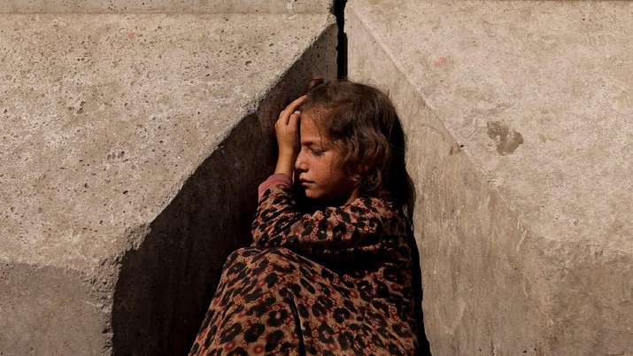 A girl sits between concrete barriers in Kabul, Afghanistan October 7, 2021. Picture taken October 7, 2021. REUTERS/Jorge Silva