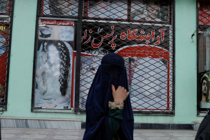 Seorang wanita Afghanistan mengenakan burqa memohon saat merawat putrinya di Kabul, Afghanistan 7 Oktober 2021. (REUTERS/Jorge Silva) An Afghan woman wearing a burqa begs while taking care of her daughter in Kabul, Afghanistan October 7, 2021. Picture taken October 7, 2021. REUTERS/Jorge Silva