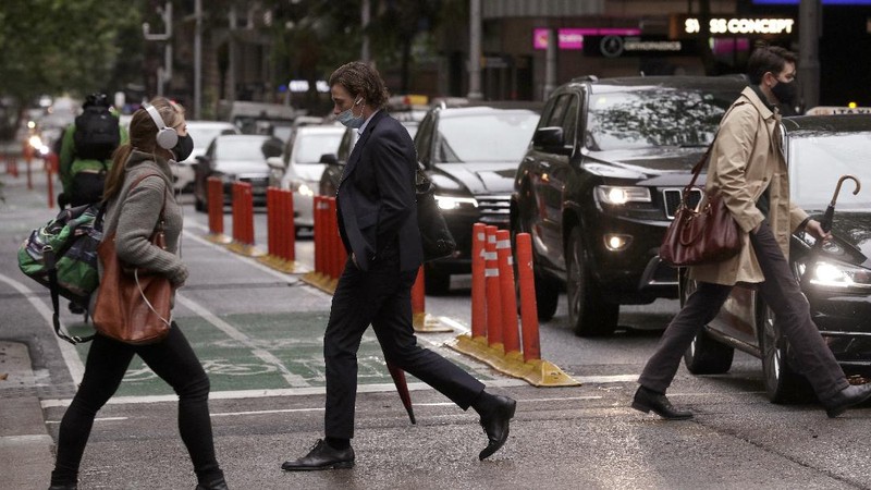 Commuters walk out of an underground train station as people filter into the city after more than 100 days of lockdown to help contain the COVID-19 outbreak in Sydney, Monday, Oct. 11, 2021. (AP Photo/Rick Rycroft)