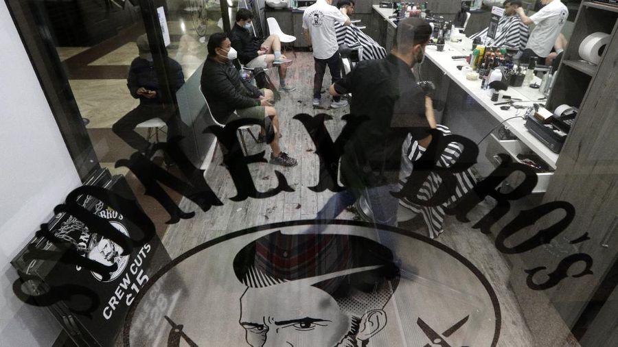 Commuters walk out of an underground train station as people filter into the city after more than 100 days of lockdown to help contain the COVID-19 outbreak in Sydney, Monday, Oct. 11, 2021. (AP Photo/Rick Rycroft)