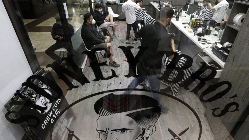 Commuters walk out of an underground train station as people filter into the city after more than 100 days of lockdown to help contain the COVID-19 outbreak in Sydney, Monday, Oct. 11, 2021. (AP Photo/Rick Rycroft)