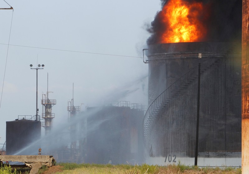 Firefighters work to extinguish a fire at an oil facility in the southern town of Zahrani, south of the port city of Sidon, Lebanon, Monday, Oct. 11, 2021. The cause of the huge fire was not immediately known. (AP Photo/Hassan Ammar)