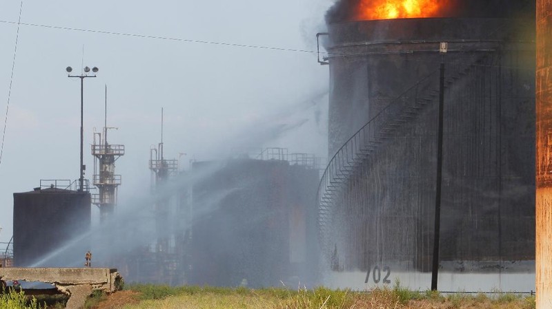Firefighters work to extinguish a fire at an oil facility in the southern town of Zahrani, south of the port city of Sidon, Lebanon, Monday, Oct. 11, 2021. The cause of the huge fire was not immediately known. (AP Photo/Hassan Ammar)