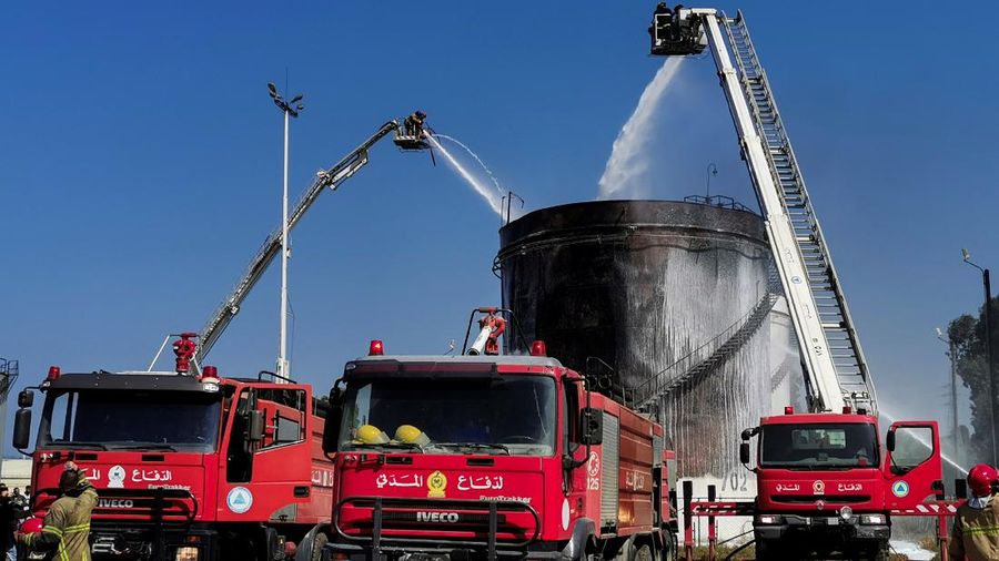 Firefighters work to extinguish a fire at an oil facility in the southern town of Zahrani, south of the port city of Sidon, Lebanon, Monday, Oct. 11, 2021. The cause of the huge fire was not immediately known. (AP Photo/Hassan Ammar)