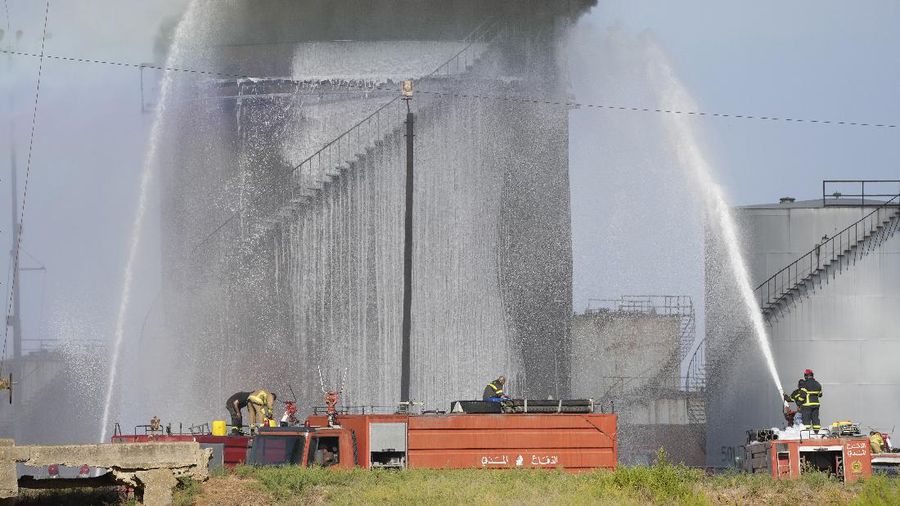 Firefighters work to extinguish a fire at an oil facility in the southern town of Zahrani, south of the port city of Sidon, Lebanon, Monday, Oct. 11, 2021. The cause of the huge fire was not immediately known. (AP Photo/Hassan Ammar)