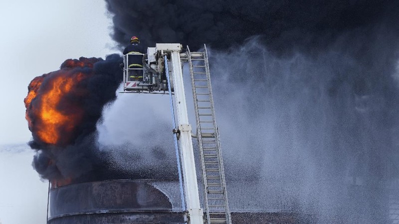 Firefighters work to extinguish a fire at an oil facility in the southern town of Zahrani, south of the port city of Sidon, Lebanon, Monday, Oct. 11, 2021. The cause of the huge fire was not immediately known. (AP Photo/Hassan Ammar)