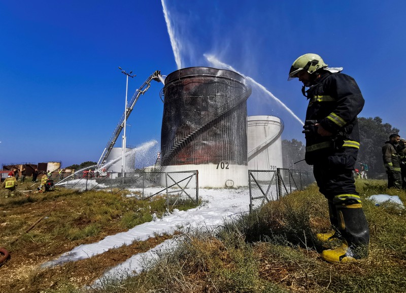 Firefighters work to extinguish a fire at an oil facility in the southern town of Zahrani, south of the port city of Sidon, Lebanon, Monday, Oct. 11, 2021. The cause of the huge fire was not immediately known. (AP Photo/Hassan Ammar)