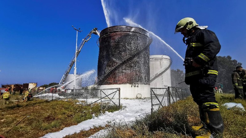 Firefighters work to extinguish a fire at an oil facility in the southern town of Zahrani, south of the port city of Sidon, Lebanon, Monday, Oct. 11, 2021. The cause of the huge fire was not immediately known. (AP Photo/Hassan Ammar)