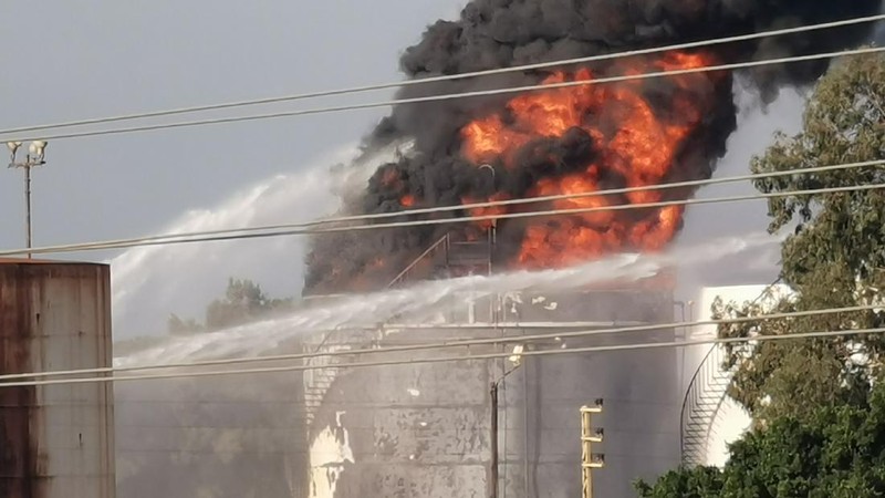 Firefighters work to extinguish a fire at an oil facility in the southern town of Zahrani, south of the port city of Sidon, Lebanon, Monday, Oct. 11, 2021. The cause of the huge fire was not immediately known. (AP Photo/Hassan Ammar)