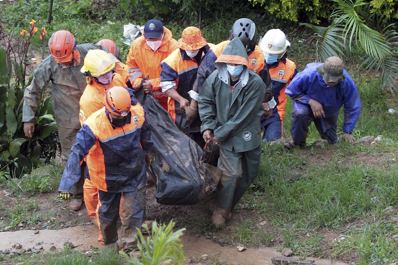In this photo released by the Gonzaga Municipal Disaster Risk Reduction and Management Office, a resident is pulled along a rope as rescuers wait on the other side of a swollen river caused by heavy rains from Tropical Storm Kompasu in Gonzaga town, Cagayan province, northern Philippines, Monday Oct. 11, 2021. A number of people have been killed and others were reported missing in landslides and flash flood set off by a storm that barreled through the tip of the northern Philippines overnight then blew away Tuesday, officials said. (Gonzaga MDRRMO via AP)