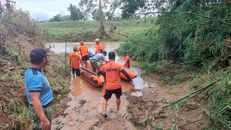 In this photo released by the Gonzaga Municipal Disaster Risk Reduction and Management Office, a resident is pulled along a rope as rescuers wait on the other side of a swollen river caused by heavy rains from Tropical Storm Kompasu in Gonzaga town, Cagayan province, northern Philippines, Monday Oct. 11, 2021. A number of people have been killed and others were reported missing in landslides and flash flood set off by a storm that barreled through the tip of the northern Philippines overnight then blew away Tuesday, officials said. (Gonzaga MDRRMO via AP)