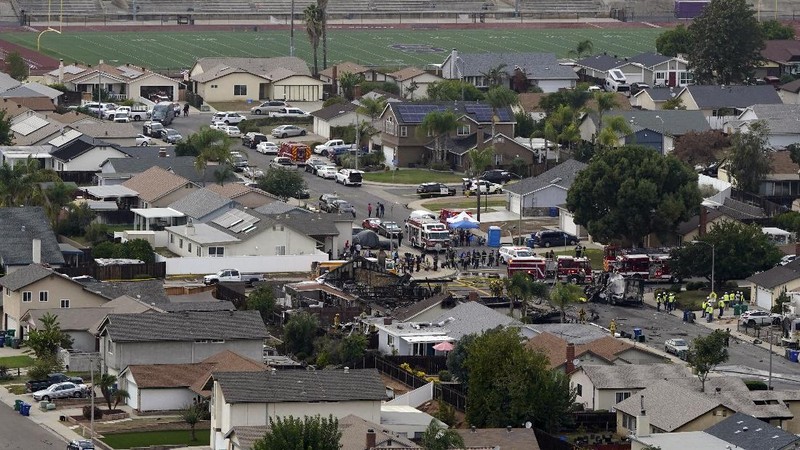 Fire crews work the scene of a small plane crash, Monday, Oct. 11, 2021, in Santee, Calif. At least two people were killed and two others were injured when the plane crashed into a suburban Southern California neighborhood, setting two homes ablaze, authorities said. (AP Photo/Gregory Bull)