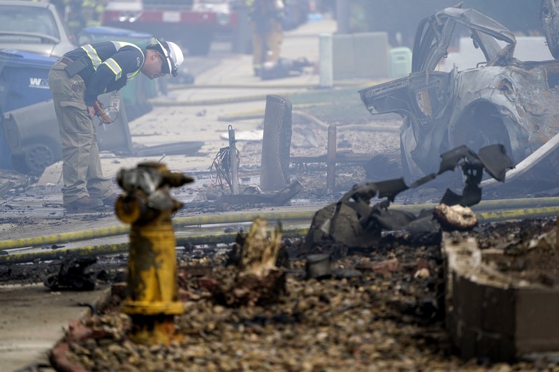 kecelakaan pesawat di Santee, California, AS Fire crews work the scene of a small plane crash, Monday, Oct. 11, 2021, in Santee, Calif. At least two people were killed and two others were injured when the plane crashed into a suburban Southern California neighborhood, setting two homes ablaze, authorities said. (AP Photo/Gregory Bull)