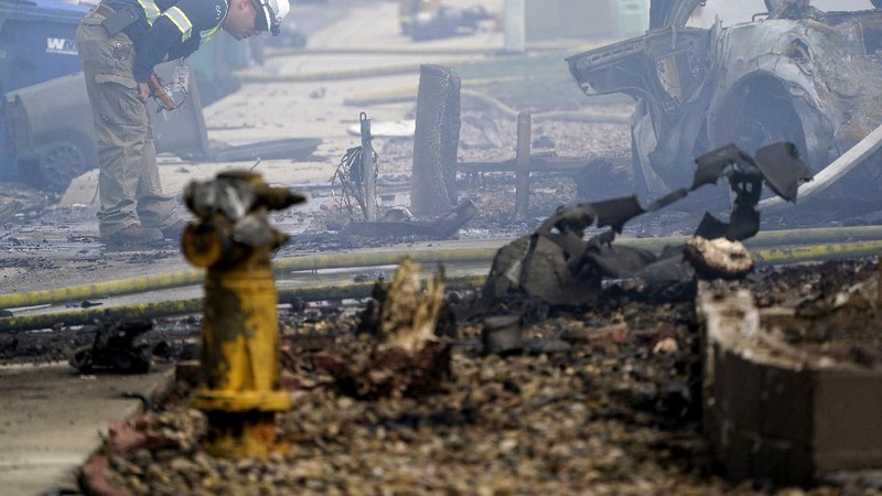 Fire crews work the scene of a small plane crash, Monday, Oct. 11, 2021, in Santee, Calif. At least two people were killed and two others were injured when the plane crashed into a suburban Southern California neighborhood, setting two homes ablaze, authorities said. (AP Photo/Gregory Bull)