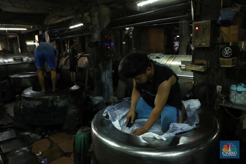 Pabrik Pewarna dan Pencucian Pakaian Pekerja menyelesaikan proses pewarnaan dan pencucian pakaian di salah satu pabrik dikawasan Jakarta, Selasa (11/10/2021). Industri tekstil dan produksi tekstil (TPT) mengalami pasang surut sejak pandemi Covid-19 sejak beberapa tahun belakangan. Setelah sebelumnya berhasil bangkit kembali pada kuartal IV 2020, Pemberlakuan Pembatasan Kegiatan Masyarakat (PPKM) mikro pada tahun ini kembali bergeliat. Kontribusi penurunan terbesar berasal dari penurunan pakaian jadi yang memiliki porsi 66% dari total ekspor TPT Indonesia. Tekanan terhadap industri TPT setidaknya masih terjadi hingga paruh pertama 2021. Kinerja TPT sedikit terbantu oleh adanya permintaan Alat Pelindung Diri atau APD untuk keperluan penanganan COVID-19. Namun permintaan terhadap APD tersebut tidak cukup besar untuk menutupi turunnya penjualan produk produk TPT secara keseluruhan. Menurut owner Helmi