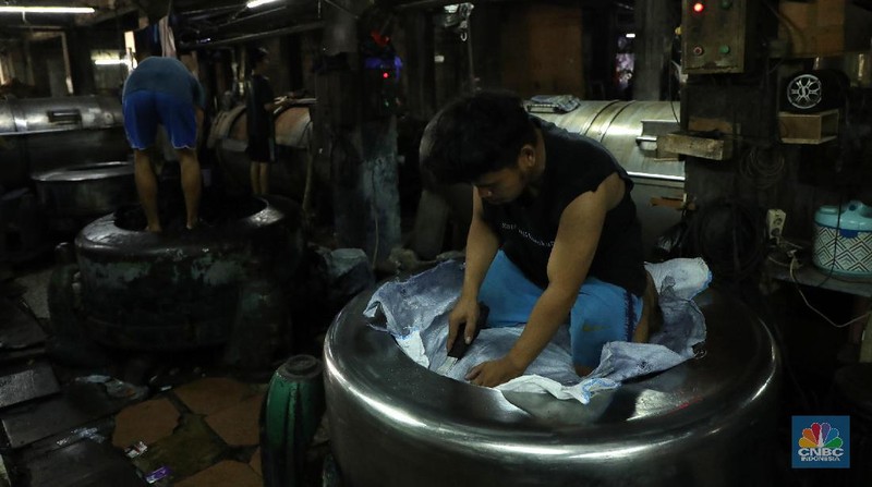 Pekerja menyelesaikan proses pewarnaan dan pencucian pakaian di salah satu pabrik dikawasan Jakarta, Selasa (11/10/2021). Industri tekstil dan produksi tekstil (TPT) mengalami pasang surut sejak pandemi Covid-19 sejak beberapa tahun belakangan. Setelah sebelumnya berhasil bangkit kembali pada kuartal IV 2020, Pemberlakuan Pembatasan Kegiatan Masyarakat (PPKM) mikro pada tahun ini kembali bergeliat. Kontribusi penurunan terbesar berasal dari penurunan pakaian jadi yang memiliki porsi 66% dari total ekspor TPT Indonesia. Tekanan terhadap industri TPT setidaknya masih terjadi hingga paruh pertama 2021. Kinerja TPT sedikit terbantu oleh adanya permintaan Alat Pelindung Diri atau APD untuk keperluan penanganan COVID-19. Namun permintaan terhadap APD tersebut tidak cukup besar untuk menutupi turunnya penjualan produk produk TPT secara keseluruhan. Menurut owner Helmi 