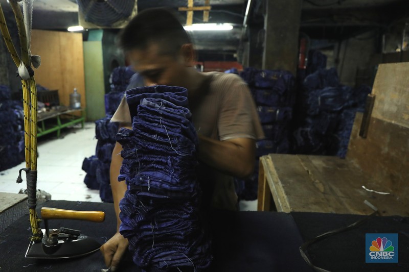 Pabrik Pewarna dan Pencucian Pakaian Pekerja menyelesaikan proses pewarnaan dan pencucian pakaian di salah satu pabrik dikawasan Jakarta, Selasa (11/10/2021). Industri tekstil dan produksi tekstil (TPT) mengalami pasang surut sejak pandemi Covid-19 sejak beberapa tahun belakangan. Setelah sebelumnya berhasil bangkit kembali pada kuartal IV 2020, Pemberlakuan Pembatasan Kegiatan Masyarakat (PPKM) mikro pada tahun ini kembali bergeliat. Kontribusi penurunan terbesar berasal dari penurunan pakaian jadi yang memiliki porsi 66% dari total ekspor TPT Indonesia. Tekanan terhadap industri TPT setidaknya masih terjadi hingga paruh pertama 2021. Kinerja TPT sedikit terbantu oleh adanya permintaan Alat Pelindung Diri atau APD untuk keperluan penanganan COVID-19. Namun permintaan terhadap APD tersebut tidak cukup besar untuk menutupi turunnya penjualan produk produk TPT secara keseluruhan. Menurut owner Helmi