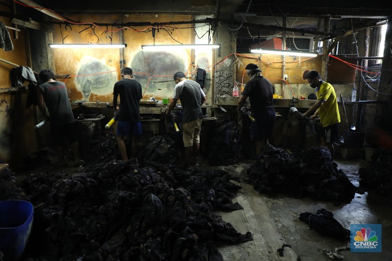 Pekerja menyelesaikan proses pewarnaan dan pencucian pakaian di salah satu pabrik dikawasan Jakarta, Selasa (11/10/2021). Industri tekstil dan produksi tekstil (TPT) mengalami pasang surut sejak pandemi Covid-19 sejak beberapa tahun belakangan. Setelah sebelumnya berhasil bangkit kembali pada kuartal IV 2020, Pemberlakuan Pembatasan Kegiatan Masyarakat (PPKM) mikro pada tahun ini kembali bergeliat. Kontribusi penurunan terbesar berasal dari penurunan pakaian jadi yang memiliki porsi 66% dari total ekspor TPT Indonesia. Tekanan terhadap industri TPT setidaknya masih terjadi hingga paruh pertama 2021. Kinerja TPT sedikit terbantu oleh adanya permintaan Alat Pelindung Diri atau APD untuk keperluan penanganan COVID-19. Namun permintaan terhadap APD tersebut tidak cukup besar untuk menutupi turunnya penjualan produk produk TPT secara keseluruhan. Menurut owner Helmi 