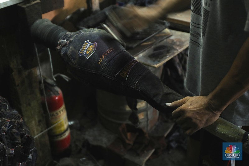 Pekerja menyelesaikan proses pewarnaan dan pencucian pakaian di salah satu pabrik dikawasan Jakarta, Selasa (11/10/2021). Industri tekstil dan produksi tekstil (TPT) mengalami pasang surut sejak pandemi Covid-19 sejak beberapa tahun belakangan. Setelah sebelumnya berhasil bangkit kembali pada kuartal IV 2020, Pemberlakuan Pembatasan Kegiatan Masyarakat (PPKM) mikro pada tahun ini kembali bergeliat. Kontribusi penurunan terbesar berasal dari penurunan pakaian jadi yang memiliki porsi 66% dari total ekspor TPT Indonesia. Tekanan terhadap industri TPT setidaknya masih terjadi hingga paruh pertama 2021. Kinerja TPT sedikit terbantu oleh adanya permintaan Alat Pelindung Diri atau APD untuk keperluan penanganan COVID-19. Namun permintaan terhadap APD tersebut tidak cukup besar untuk menutupi turunnya penjualan produk produk TPT secara keseluruhan. Menurut owner Helmi 