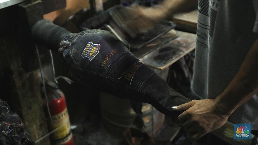 Pekerja menyelesaikan proses pewarnaan dan pencucian pakaian di salah satu pabrik dikawasan Jakarta, Selasa (11/10/2021). Industri tekstil dan produksi tekstil (TPT) mengalami pasang surut sejak pandemi Covid-19 sejak beberapa tahun belakangan. Setelah sebelumnya berhasil bangkit kembali pada kuartal IV 2020, Pemberlakuan Pembatasan Kegiatan Masyarakat (PPKM) mikro pada tahun ini kembali bergeliat. Kontribusi penurunan terbesar berasal dari penurunan pakaian jadi yang memiliki porsi 66% dari total ekspor TPT Indonesia. Tekanan terhadap industri TPT setidaknya masih terjadi hingga paruh pertama 2021. Kinerja TPT sedikit terbantu oleh adanya permintaan Alat Pelindung Diri atau APD untuk keperluan penanganan COVID-19. Namun permintaan terhadap APD tersebut tidak cukup besar untuk menutupi turunnya penjualan produk produk TPT secara keseluruhan. Menurut owner Helmi 