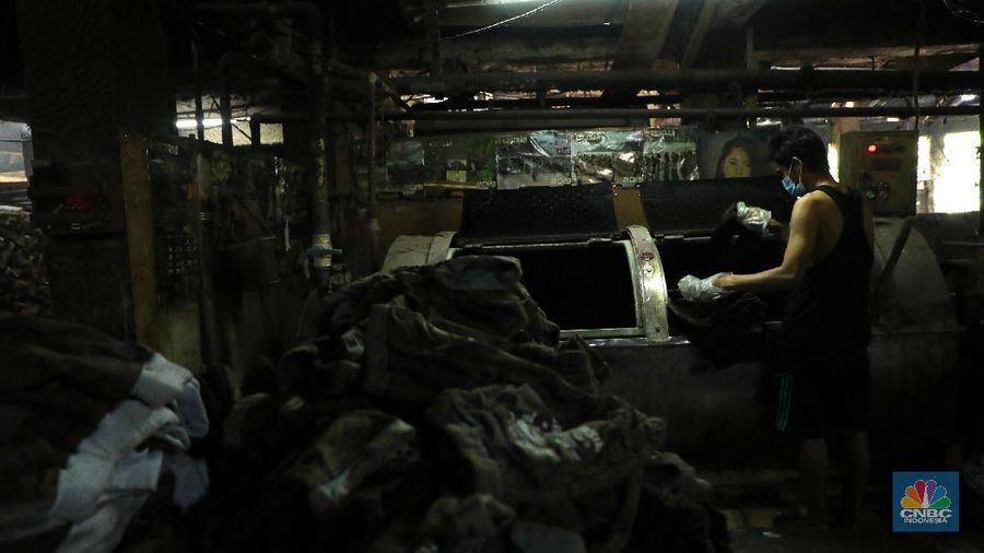 Pekerja menyelesaikan proses pewarnaan dan pencucian pakaian di salah satu pabrik dikawasan Jakarta, Selasa (11/10/2021). Industri tekstil dan produksi tekstil (TPT) mengalami pasang surut sejak pandemi Covid-19 sejak beberapa tahun belakangan. Setelah sebelumnya berhasil bangkit kembali pada kuartal IV 2020, Pemberlakuan Pembatasan Kegiatan Masyarakat (PPKM) mikro pada tahun ini kembali bergeliat. Kontribusi penurunan terbesar berasal dari penurunan pakaian jadi yang memiliki porsi 66% dari total ekspor TPT Indonesia. Tekanan terhadap industri TPT setidaknya masih terjadi hingga paruh pertama 2021. Kinerja TPT sedikit terbantu oleh adanya permintaan Alat Pelindung Diri atau APD untuk keperluan penanganan COVID-19. Namun permintaan terhadap APD tersebut tidak cukup besar untuk menutupi turunnya penjualan produk produk TPT secara keseluruhan. Menurut owner Helmi 