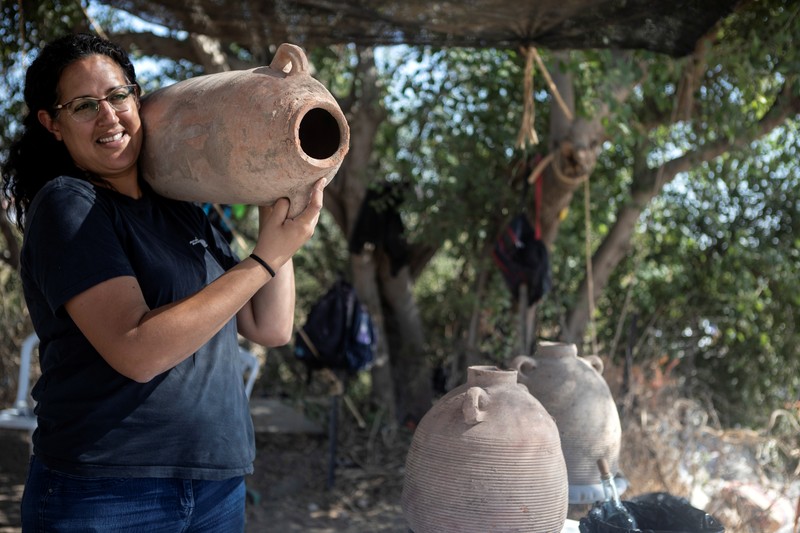 situs yang diduga bekas pabrik anggur di Israel Liat Nadav-Ziv, salah satu direktur Otoritas Barang Antik Israel membawa Jar Gaza saat menemukan sisa-sisa kilang anggur Bizantium berusia 1500 tahun di Yavne, Israel (11/10/2021). (REUTERS/Nir Elias)