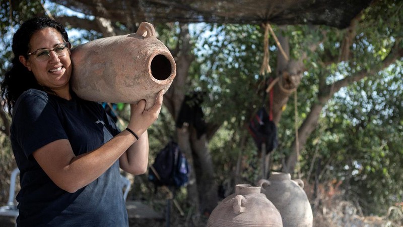 Liat Nadav-Ziv, salah satu direktur Otoritas Barang Antik Israel membawa Jar Gaza saat menemukan sisa-sisa kilang anggur Bizantium berusia 1500 tahun di Yavne, Israel (11/10/2021). (REUTERS/Nir Elias)