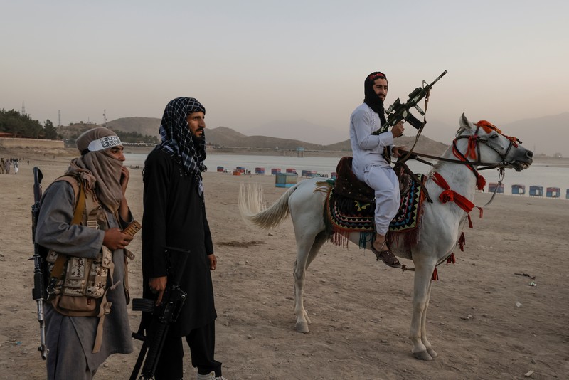 Pejuang Taliban Afghanistan cuti liburan rekreasi Taliban fighters get out of a vehicle as they take a day off to visit the amusement park at Kabul's Qargha reservoir, at the outskirts of Kabul, Afghanistan October 8, 2021. Picture taken October 8, 2021. REUTERS/Jorge Silva TPX IMAGES OF THE DAY