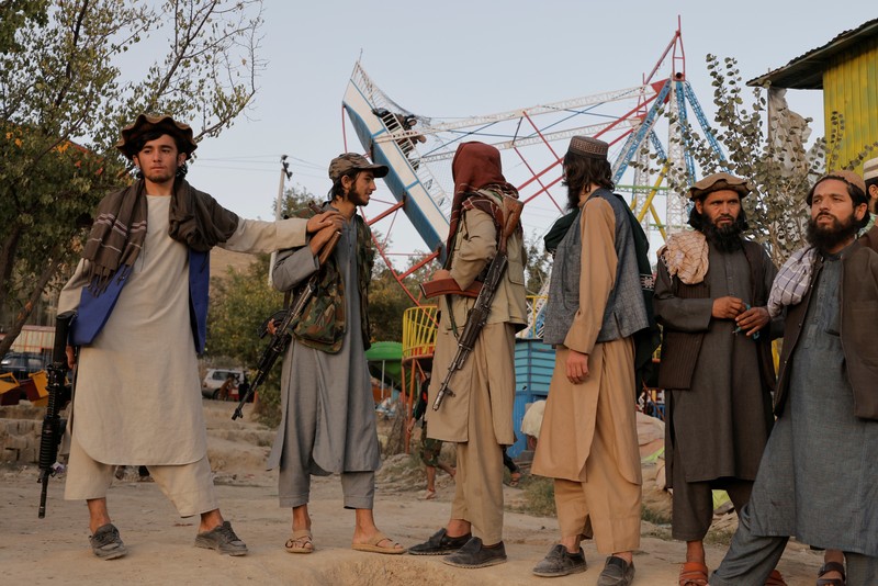 Pejuang Taliban Afghanistan cuti liburan rekreasi Taliban fighters get out of a vehicle as they take a day off to visit the amusement park at Kabul's Qargha reservoir, at the outskirts of Kabul, Afghanistan October 8, 2021. Picture taken October 8, 2021. REUTERS/Jorge Silva TPX IMAGES OF THE DAY