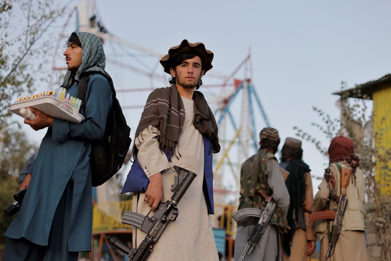 Pejuang Taliban Afghanistan cuti liburan rekreasi Taliban fighters get out of a vehicle as they take a day off to visit the amusement park at Kabul's Qargha reservoir, at the outskirts of Kabul, Afghanistan October 8, 2021. Picture taken October 8, 2021. REUTERS/Jorge Silva TPX IMAGES OF THE DAY