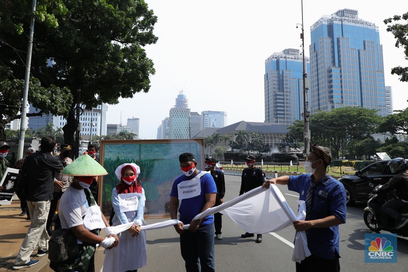 Demonstran yang tergabung dalam Serikat Pekerja Rokok Tembakau Makanan Minuman melakukan aksi berjalan kaki menuju istana negara untuk menyerahkan lukisan di Jakarta, Rabu (13/10/2021). Aksi penyerahan lukisan bergambar buruh petani tembakau kepada Presiden Jokowi ini sebagai bentuk protes atas rencana kenaikan tarif cukai hasil tembakau (CHT) atau cukai rokok tahun depan. Sebelumnya, sebagian pendemo menggelar aksi teaterikal di patung kuda hingga pihak kepolisian memberikan izin untuk perwakilan massa untuk memberikan lukisan ke Istana Presiden. (CNBC Indonesia/ Tri Susilo)