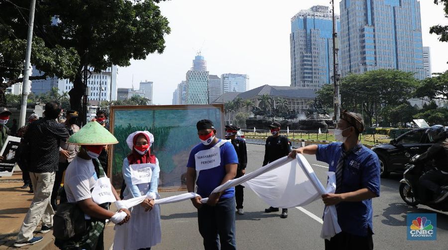 Demonstran yang tergabung dalam Serikat Pekerja Rokok Tembakau Makanan Minuman melakukan aksi berjalan kaki menuju istana negara untuk menyerahkan lukisan di Jakarta, Rabu (13/10/2021). Aksi penyerahan lukisan bergambar buruh petani tembakau kepada Presiden Jokowi ini sebagai bentuk protes atas rencana kenaikan tarif cukai hasil tembakau (CHT) atau cukai rokok tahun depan. Sebelumnya, sebagian pendemo menggelar aksi teaterikal di patung kuda hingga pihak kepolisian memberikan izin untuk perwakilan massa untuk memberikan lukisan ke Istana Presiden. (CNBC Indonesia/ Tri Susilo)