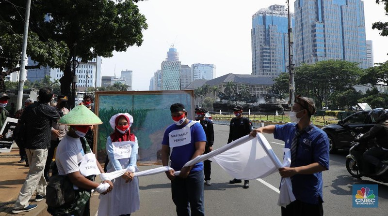 Demonstran yang tergabung dalam Serikat Pekerja Rokok Tembakau Makanan Minuman melakukan aksi berjalan kaki menuju istana negara untuk menyerahkan lukisan di Jakarta, Rabu (13/10/2021). Aksi penyerahan lukisan bergambar buruh petani tembakau kepada Presiden Jokowi ini sebagai bentuk protes atas rencana kenaikan tarif cukai hasil tembakau (CHT) atau cukai rokok tahun depan. Sebelumnya, sebagian pendemo menggelar aksi teaterikal di patung kuda hingga pihak kepolisian memberikan izin untuk perwakilan massa untuk memberikan lukisan ke Istana Presiden. (CNBC Indonesia/ Tri Susilo)