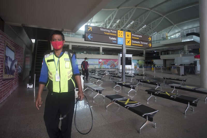 Bandara Internasional Ngurah Rai di Bali Bersiap Sambut Turis An airport worker marks queue line for the reopening of International Ngurah Rai Airport in Bali, Indonesia, Thursday, Oct. 14, 2021. The Indonesian resort island of Bali welcomed international travelers to its shops and white-sand beaches for the first time in more than a year Thursday - if they're vaccinated, test negative, hail from certain countries, quarantine and heed restrictions in public. (AP Photo/Firdia Lisnawati)
