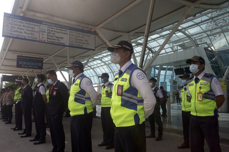 Bandara Internasional Ngurah Rai di Bali Bersiap Sambut Turis An airport worker marks queue line for the reopening of International Ngurah Rai Airport in Bali, Indonesia, Thursday, Oct. 14, 2021. The Indonesian resort island of Bali welcomed international travelers to its shops and white-sand beaches for the first time in more than a year Thursday - if they're vaccinated, test negative, hail from certain countries, quarantine and heed restrictions in public. (AP Photo/Firdia Lisnawati)