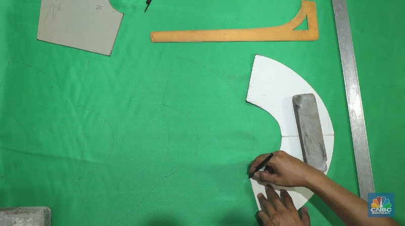 Pekerja menyelesaikan pembuatan baju wisuda (toga) di  kawasan Jakarta, Kamis (14/10/2021). Soleha (67) bisnis pembuatan baju toga sudah berjalan selama 28 tahun dan pandemi ini efeknya sangat luar biasa menurutnya. 

