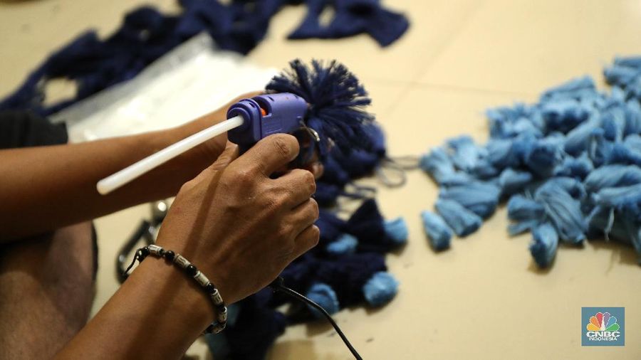 Pekerja menyelesaikan pembuatan baju wisuda (toga) di  kawasan Jakarta, Kamis (14/10/2021). Soleha (67) bisnis pembuatan baju toga sudah berjalan selama 28 tahun dan pandemi ini efeknya sangat luar biasa menurutnya. 

