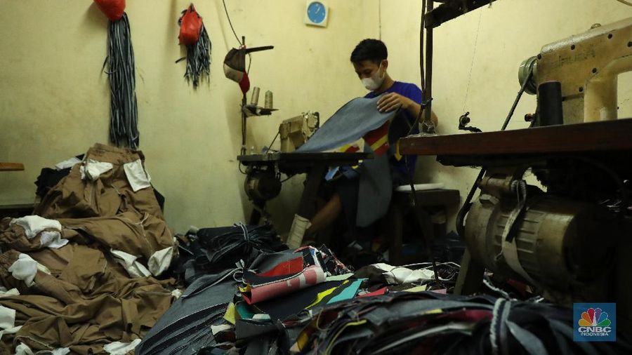 Pekerja menyelesaikan pembuatan baju wisuda (toga) di  kawasan Jakarta, Kamis (14/10/2021). Soleha (67) bisnis pembuatan baju toga sudah berjalan selama 28 tahun dan pandemi ini efeknya sangat luar biasa menurutnya. 

