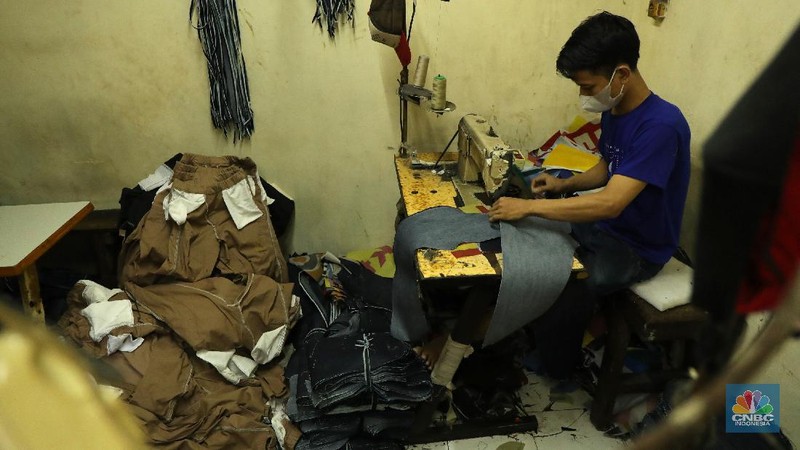 Pekerja menyelesaikan pembuatan baju wisuda (toga) di  kawasan Jakarta, Kamis (14/10/2021). Soleha (67) bisnis pembuatan baju toga sudah berjalan selama 28 tahun dan pandemi ini efeknya sangat luar biasa menurutnya. 

